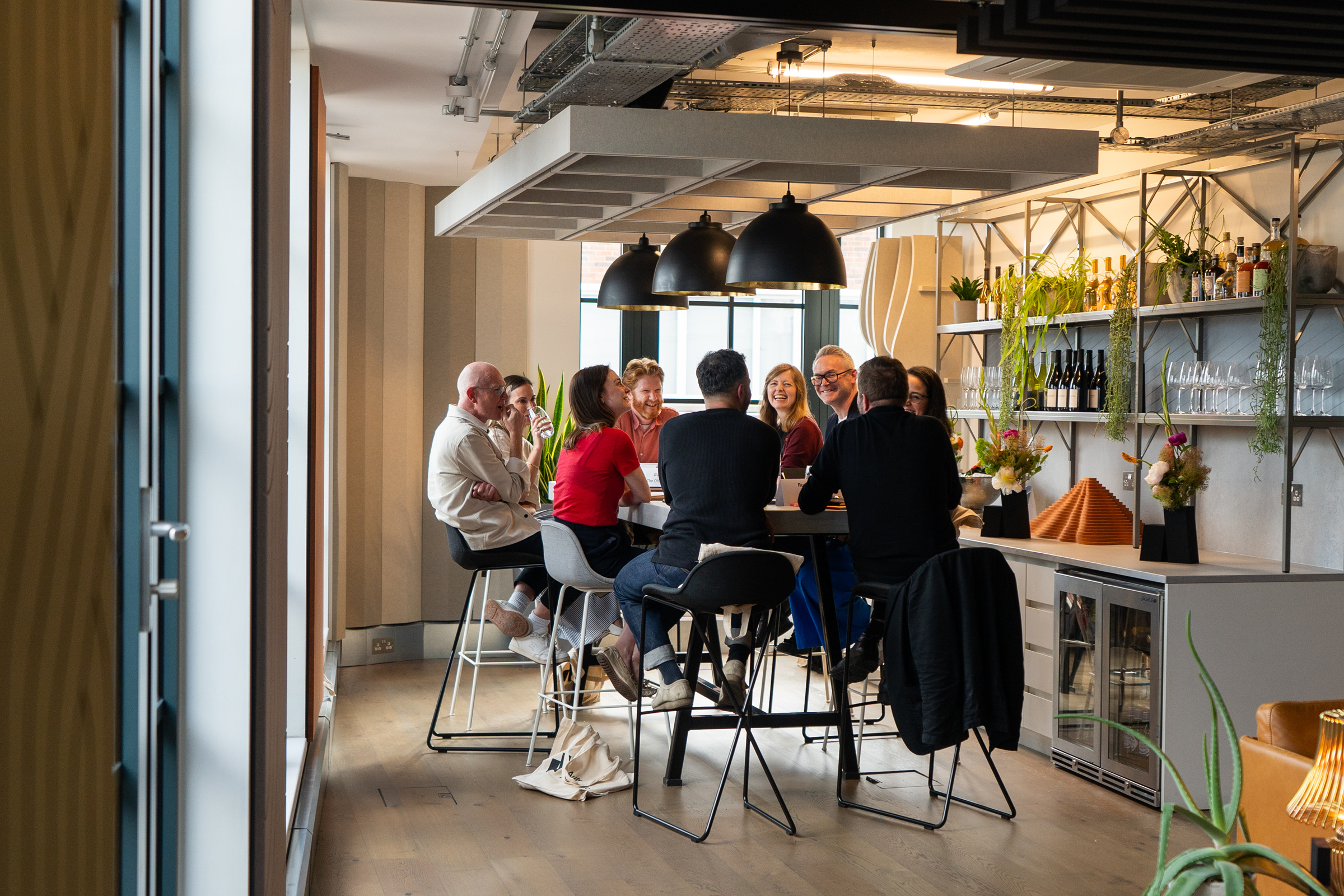 A group of people sitting around a table in the Auetx Acoustics® London showroom.